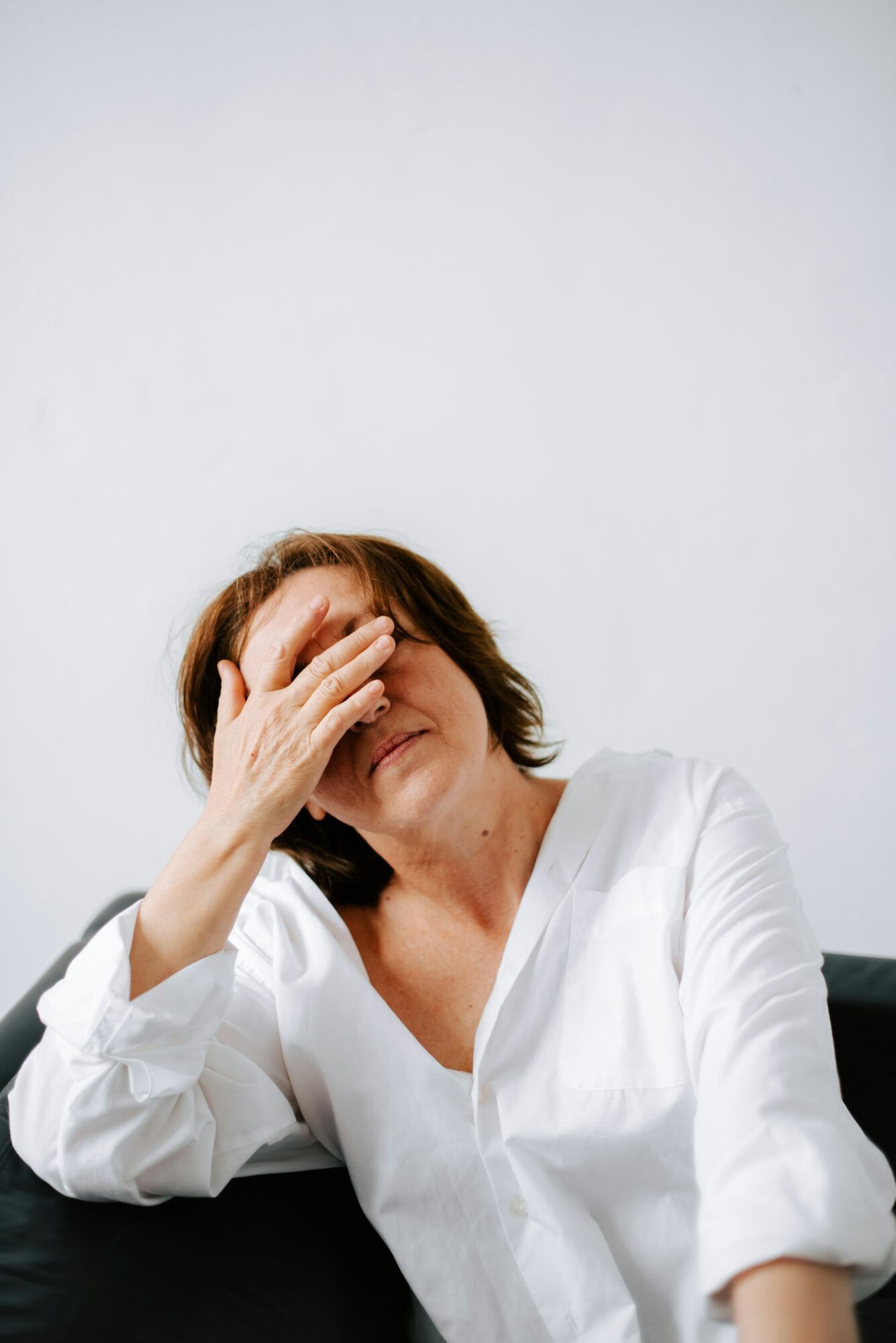 Young woman experiencing headache and fatigue at home.